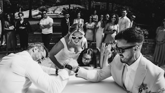 Wedding guests watch arm wrestling match at reception.