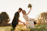 Newlyweds embracing in a sunlit grassy field