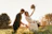 Newlyweds embracing in a sunlit grassy field