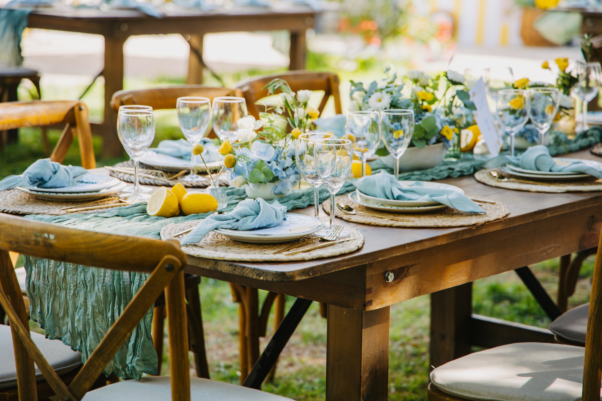A beautifully set outdoor table with blue and yellow decor.