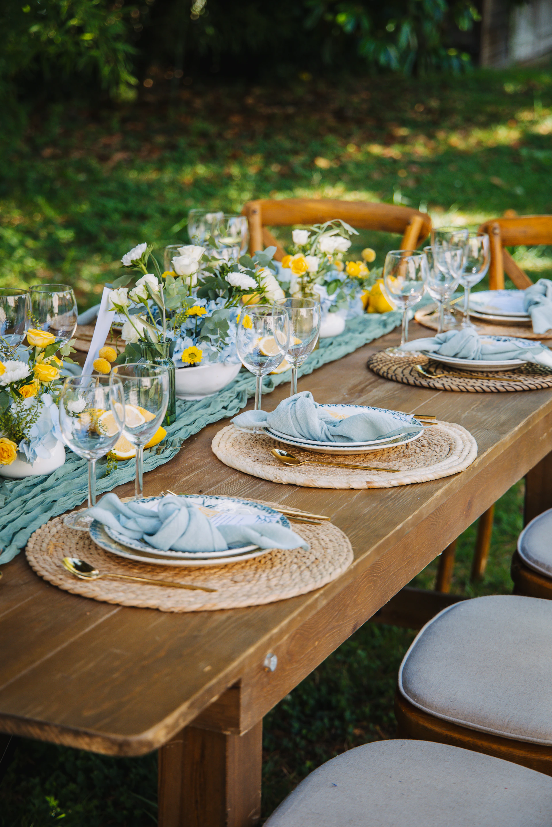 A beautifully set outdoor dining table with floral arrangements.