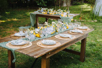 Outdoor table setting with lemons and floral arrangements