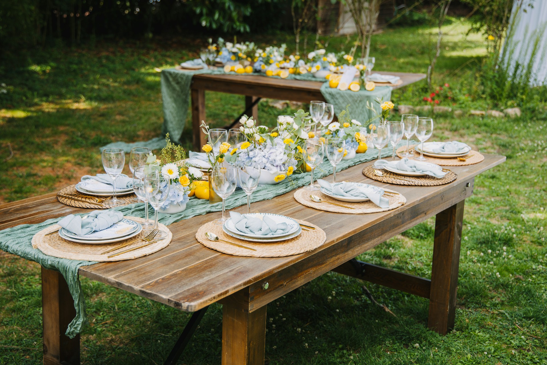 Outdoor table setting with lemons and floral arrangements
