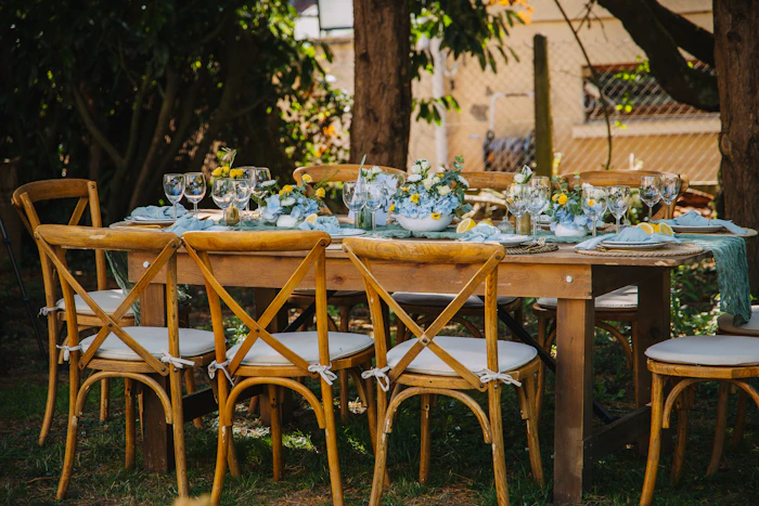 Grande table en bois dressée pour un dîner dans un jardin