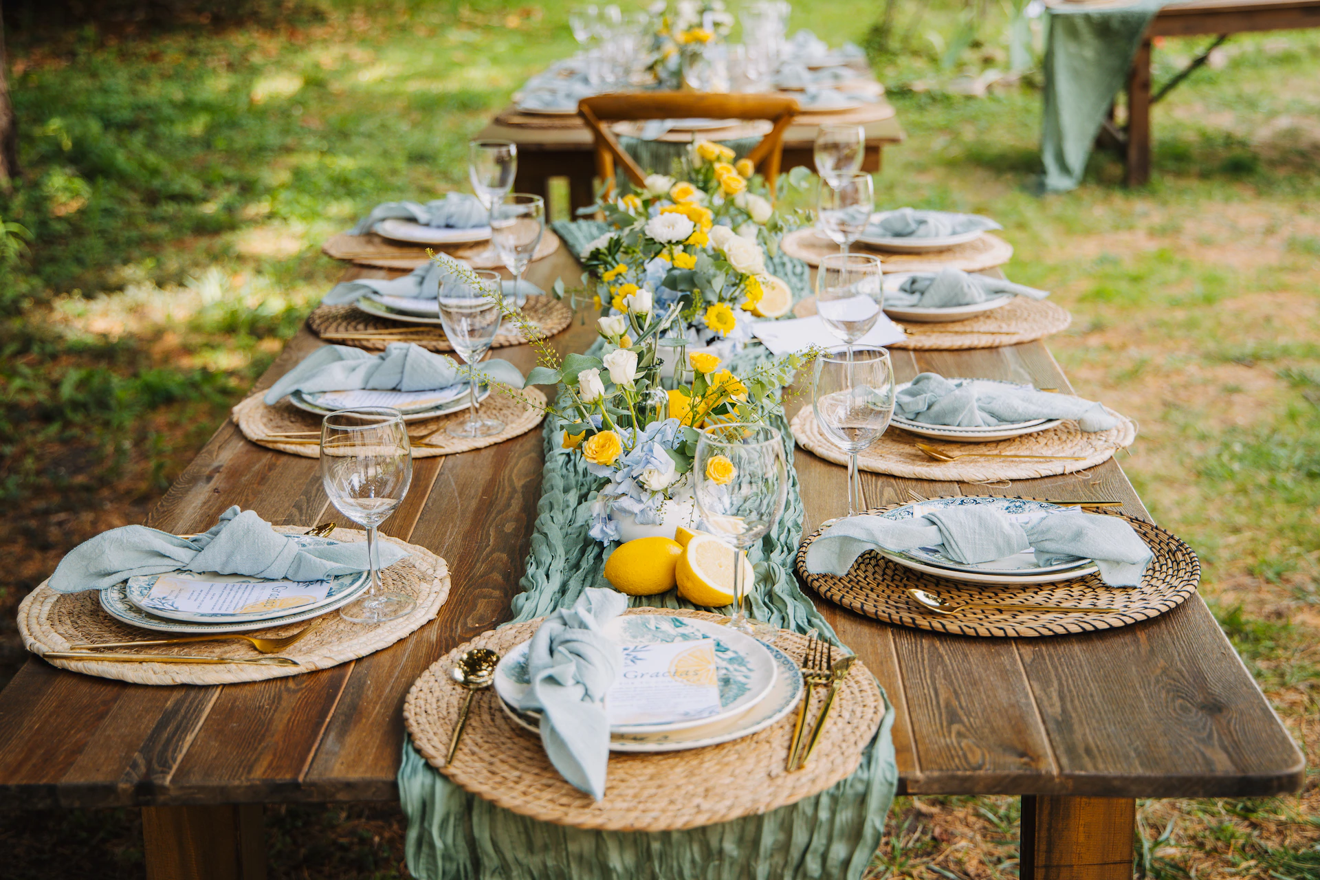 Outdoor table setting with floral centerpiece and lemons.