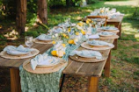 Outdoor dining table set for a party with floral decorations.