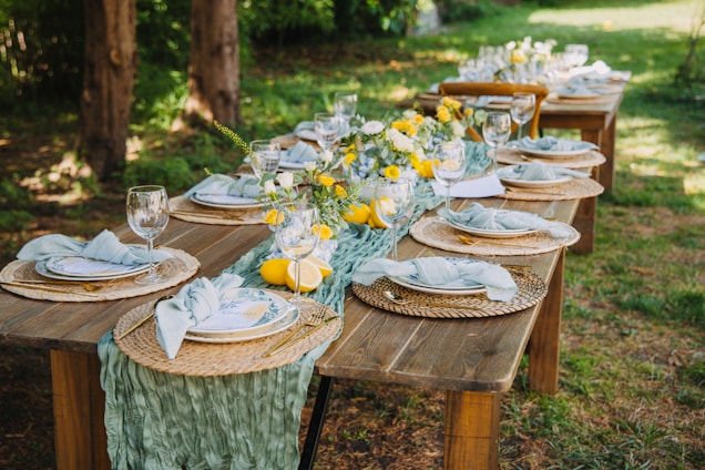 Outdoor dining table set for a party with floral decorations.