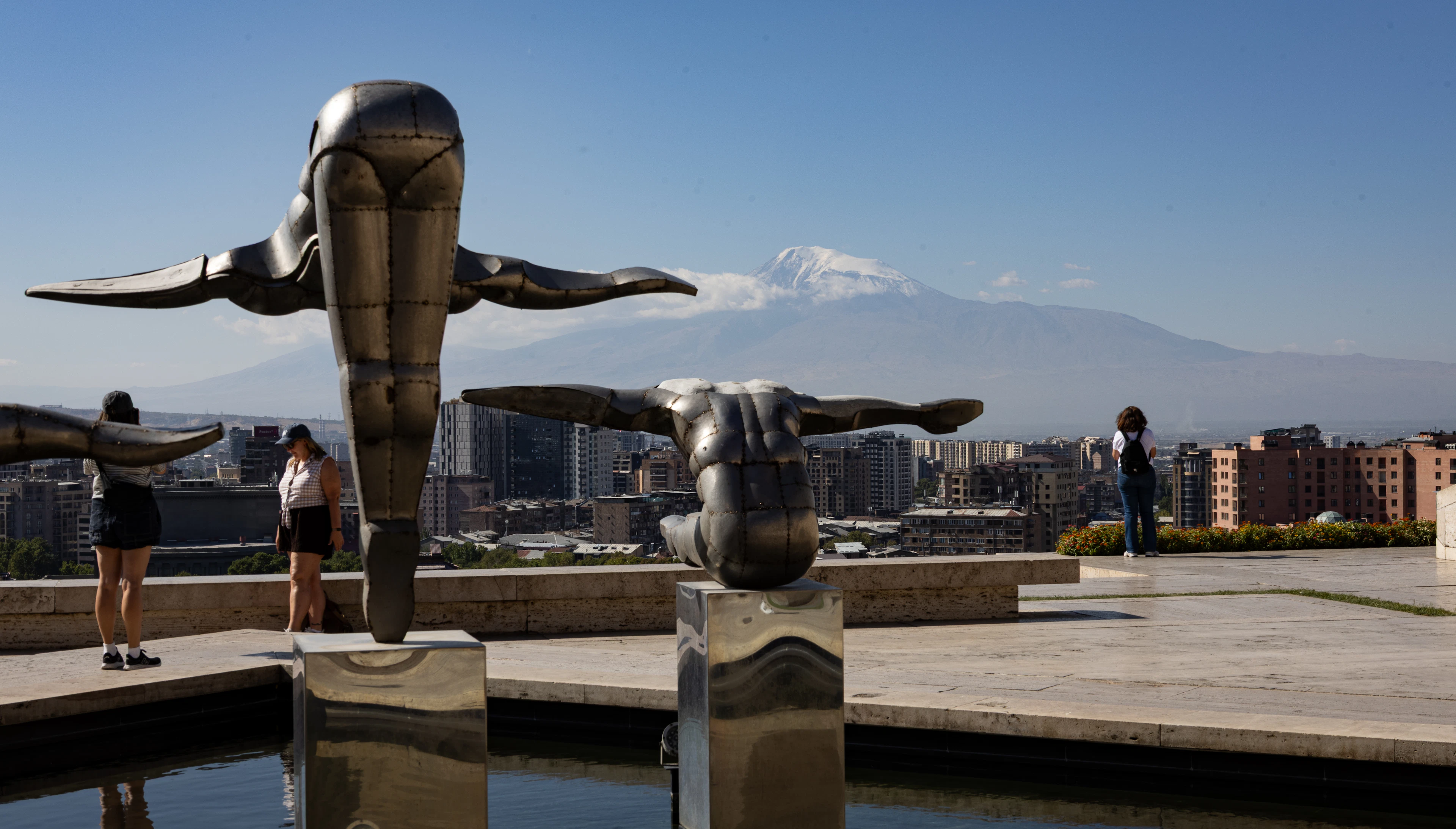 Bronze sculptures on the Cascade terrace in Yerevan with the snow on Mount Ararat behind