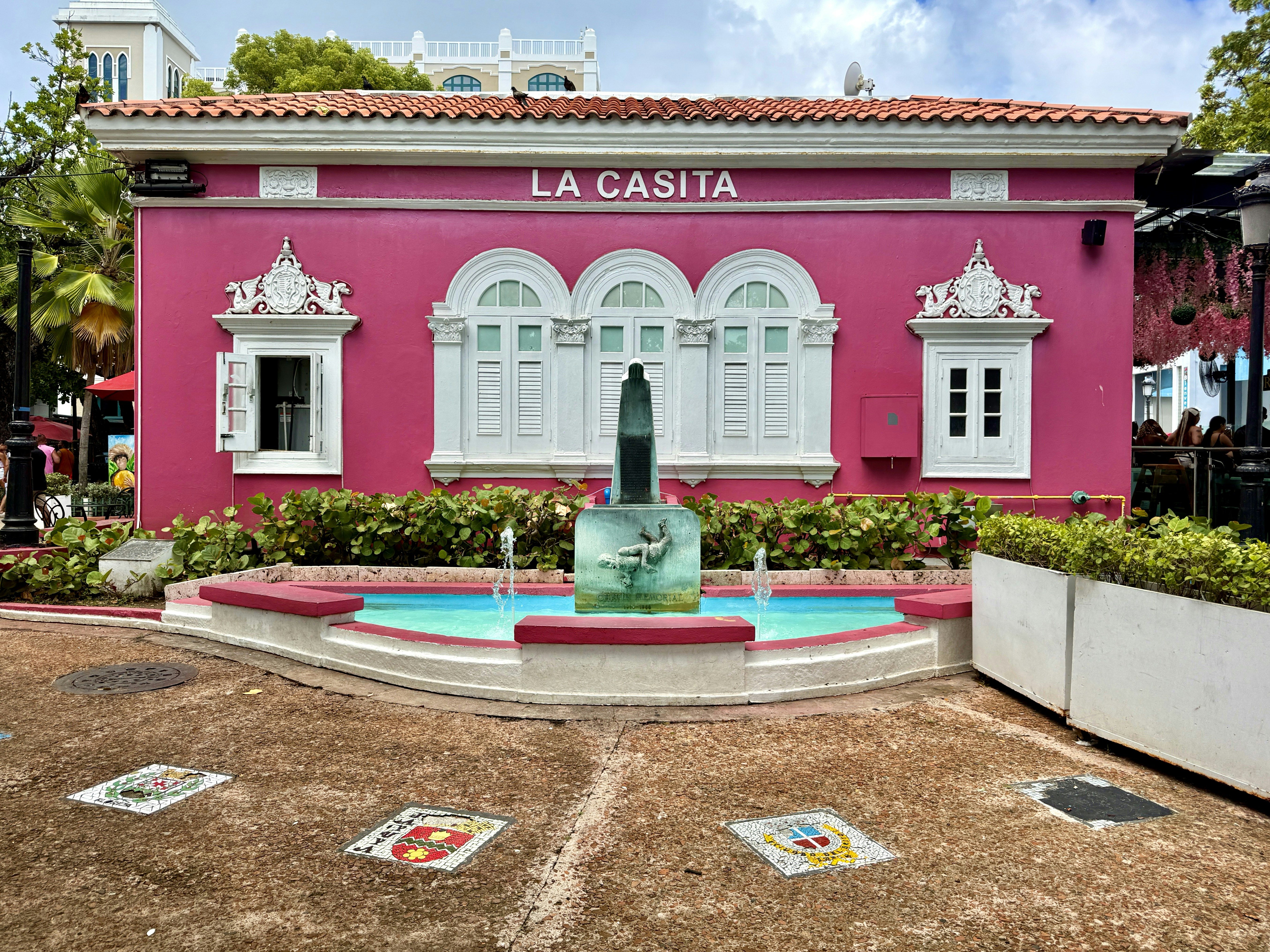 Rosafarbenes Gebäude mit Brunnen und Bogenfenstern