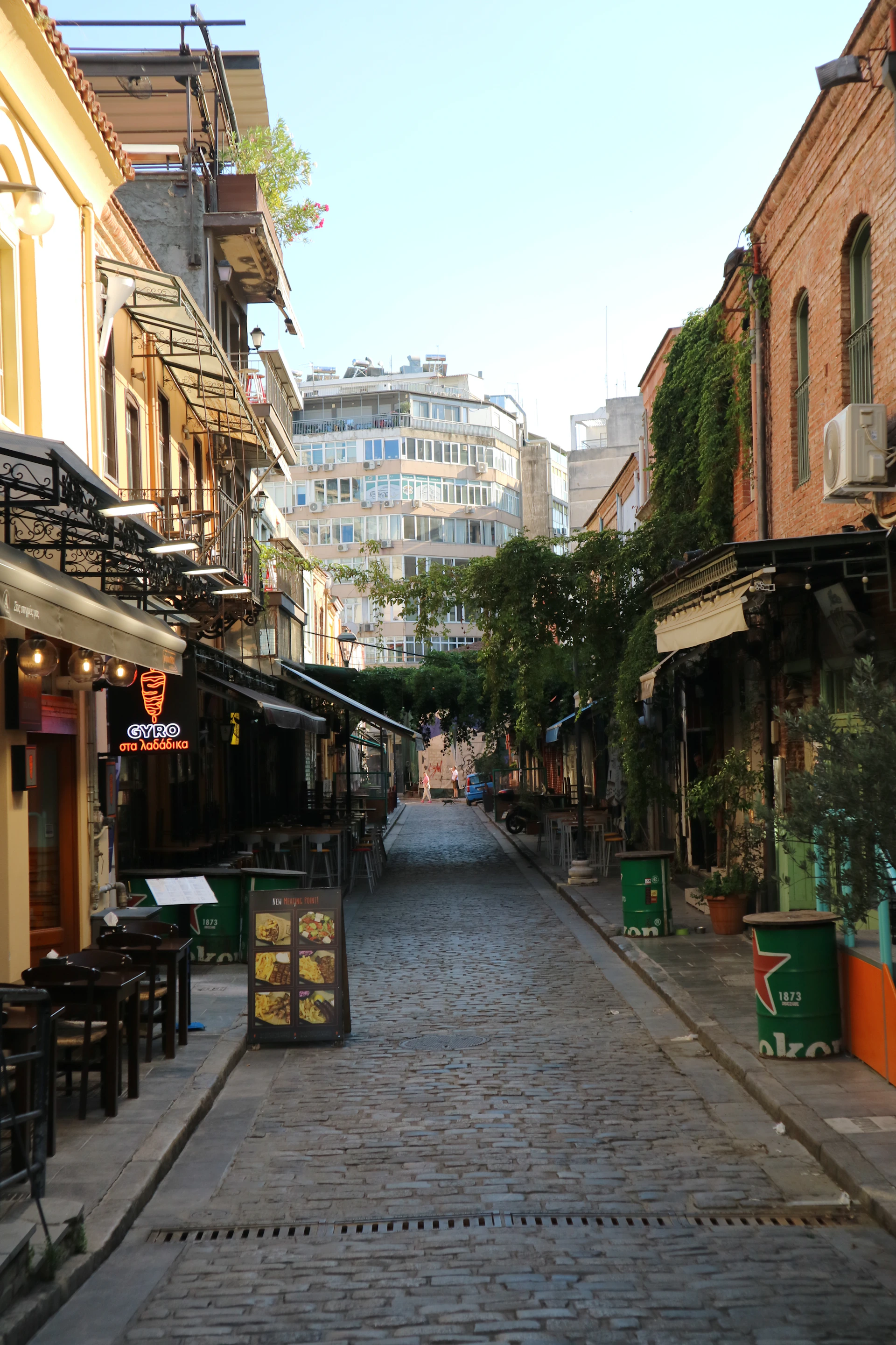 Cobblestone street lined with shops and cafes.