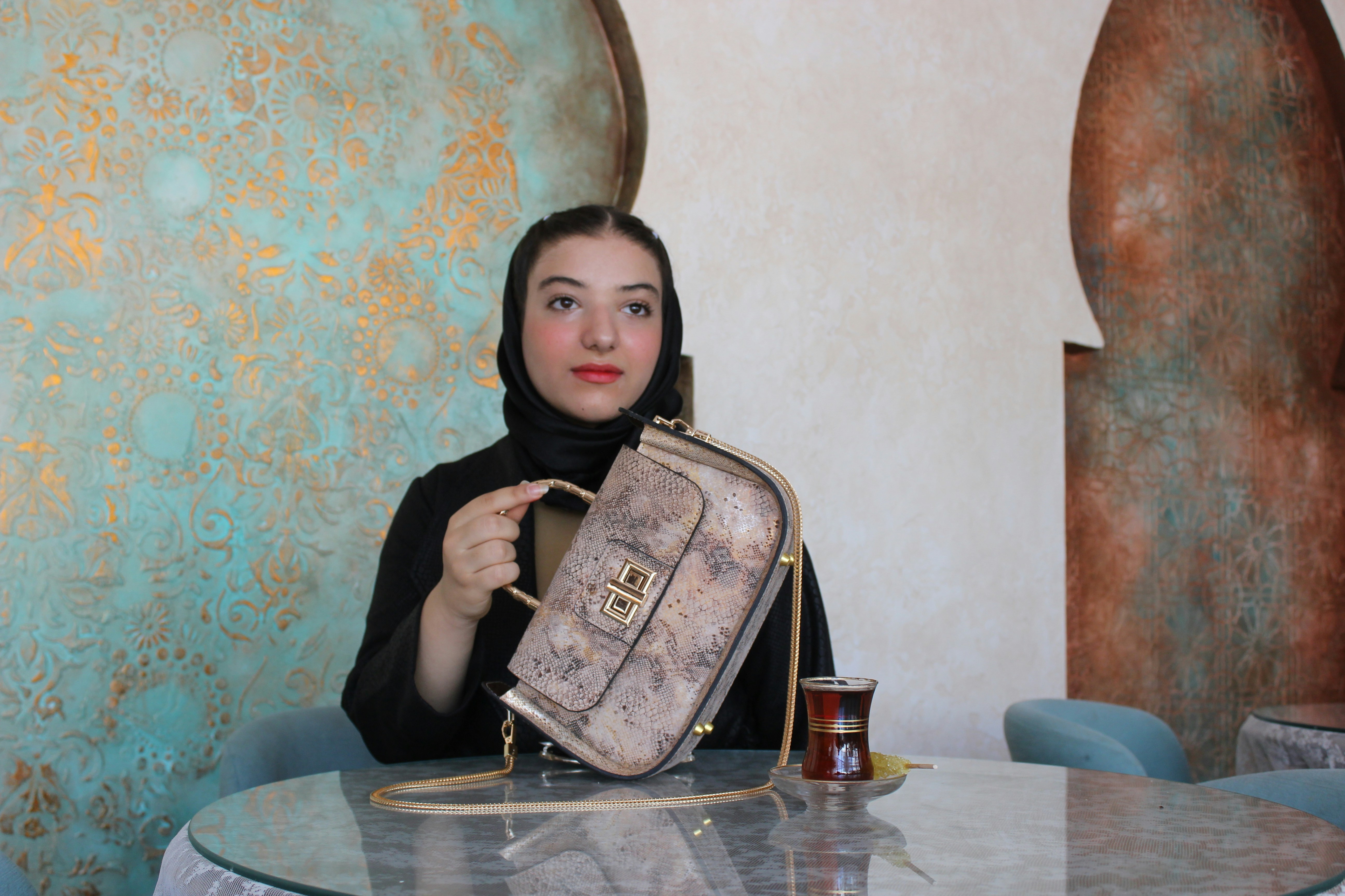 Woman in hijab holding a stylish handbag