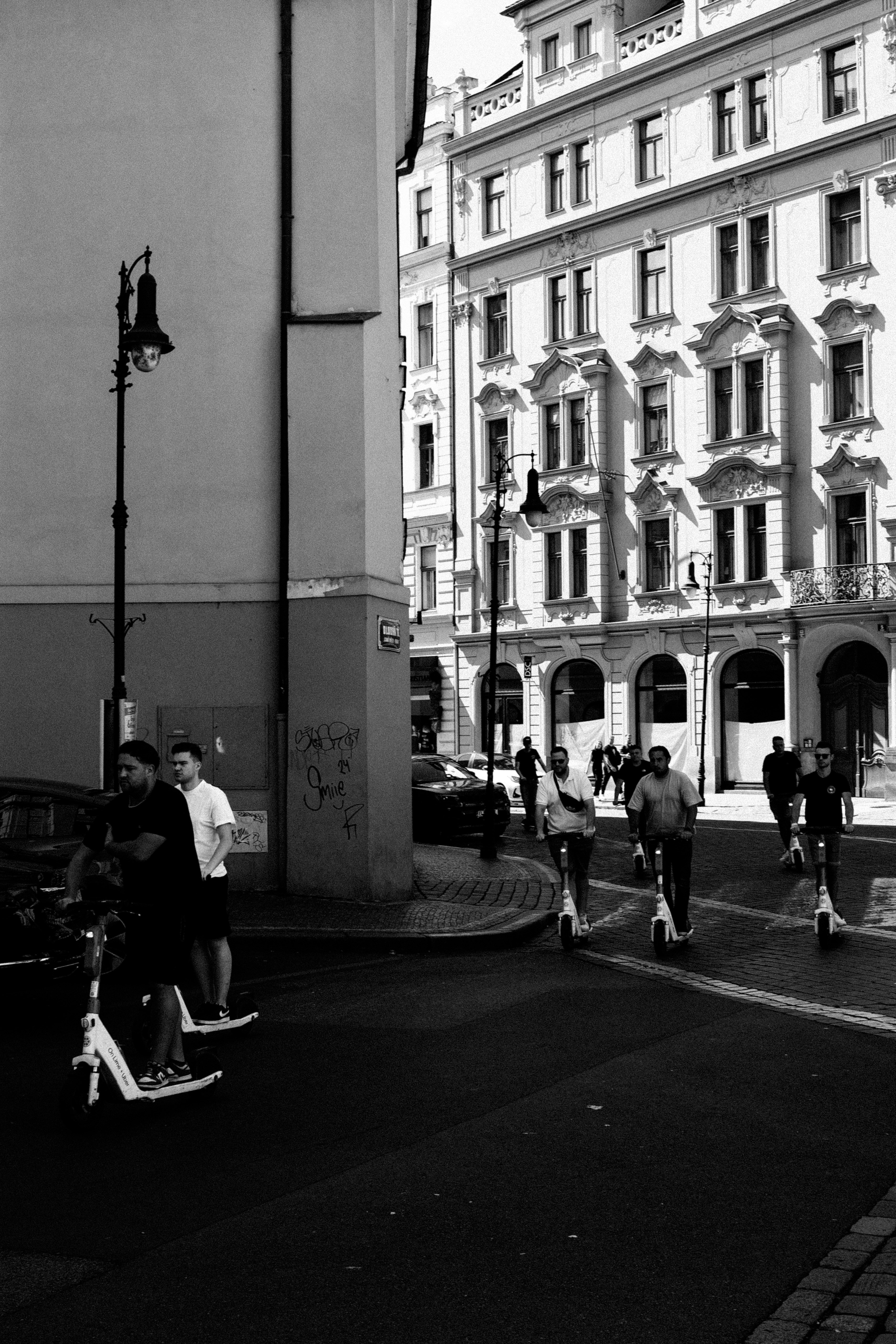 People riding electric scooters on a city street