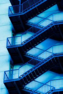 External metal staircases ascend a building facade