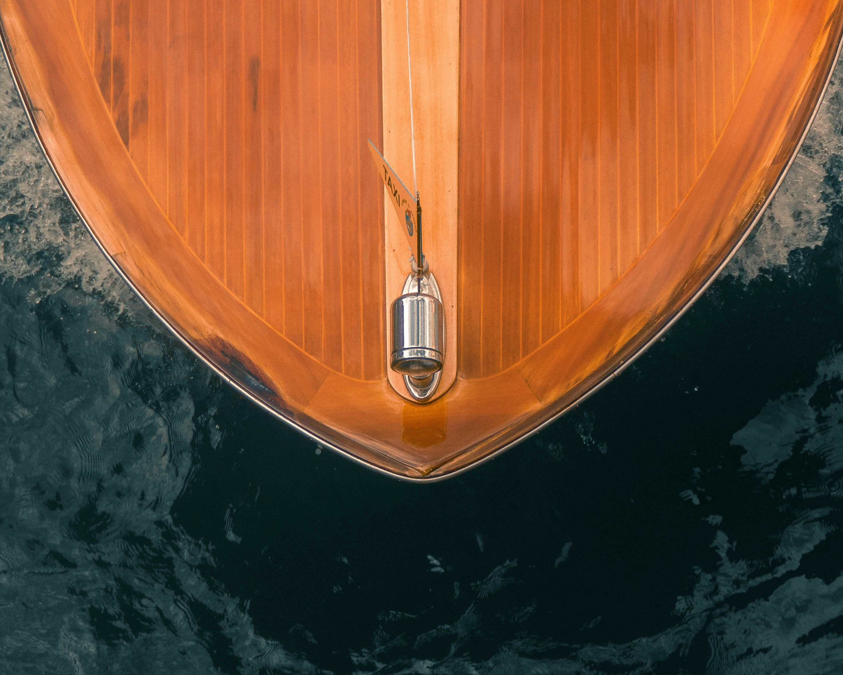 Bug eines Holzbootes, das durch dunkles Wasser schneidet