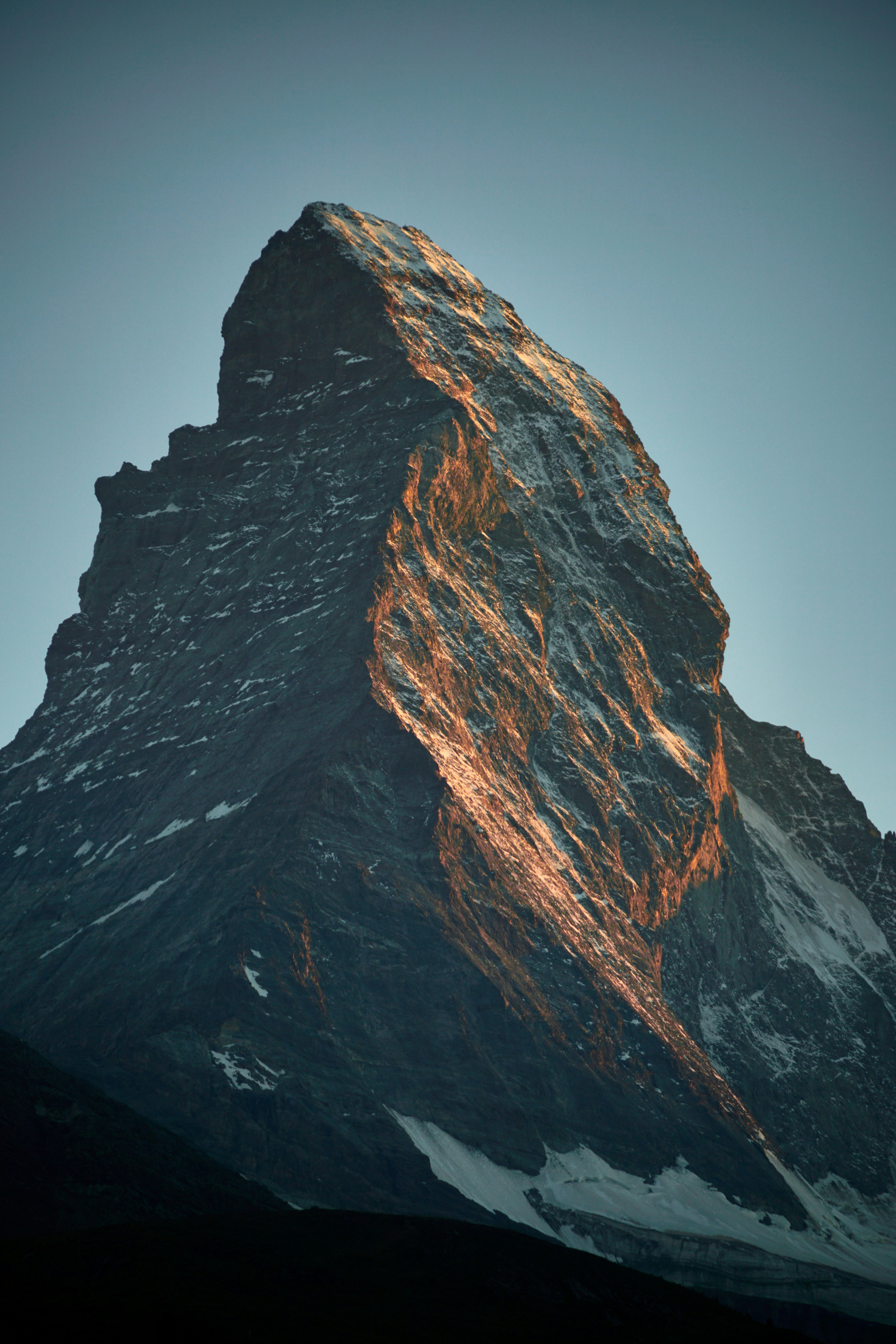 Majestuoso pico de montaña iluminado por la luz del sol de la hora dorada.