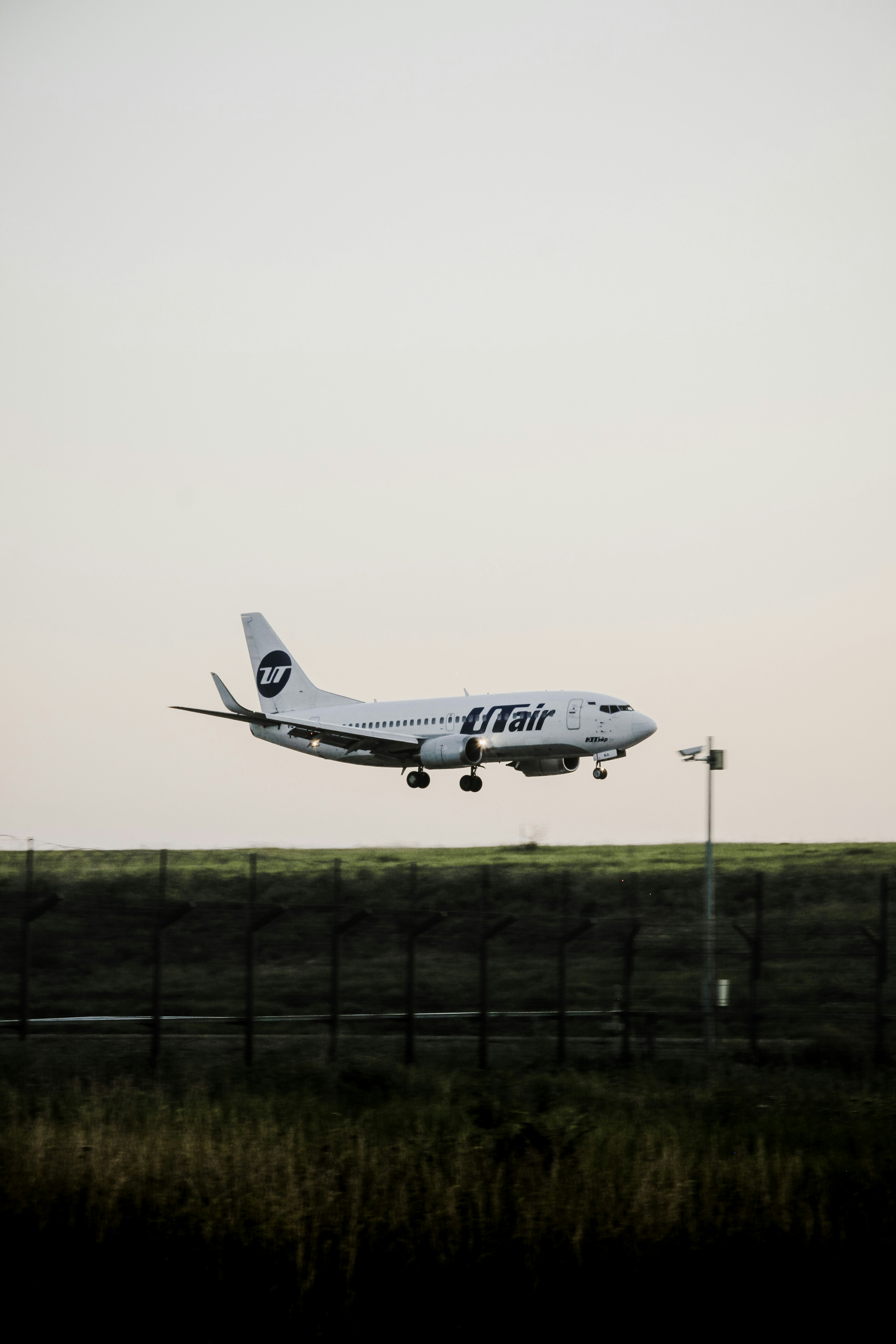 A white airplane with "utair" logo landing.