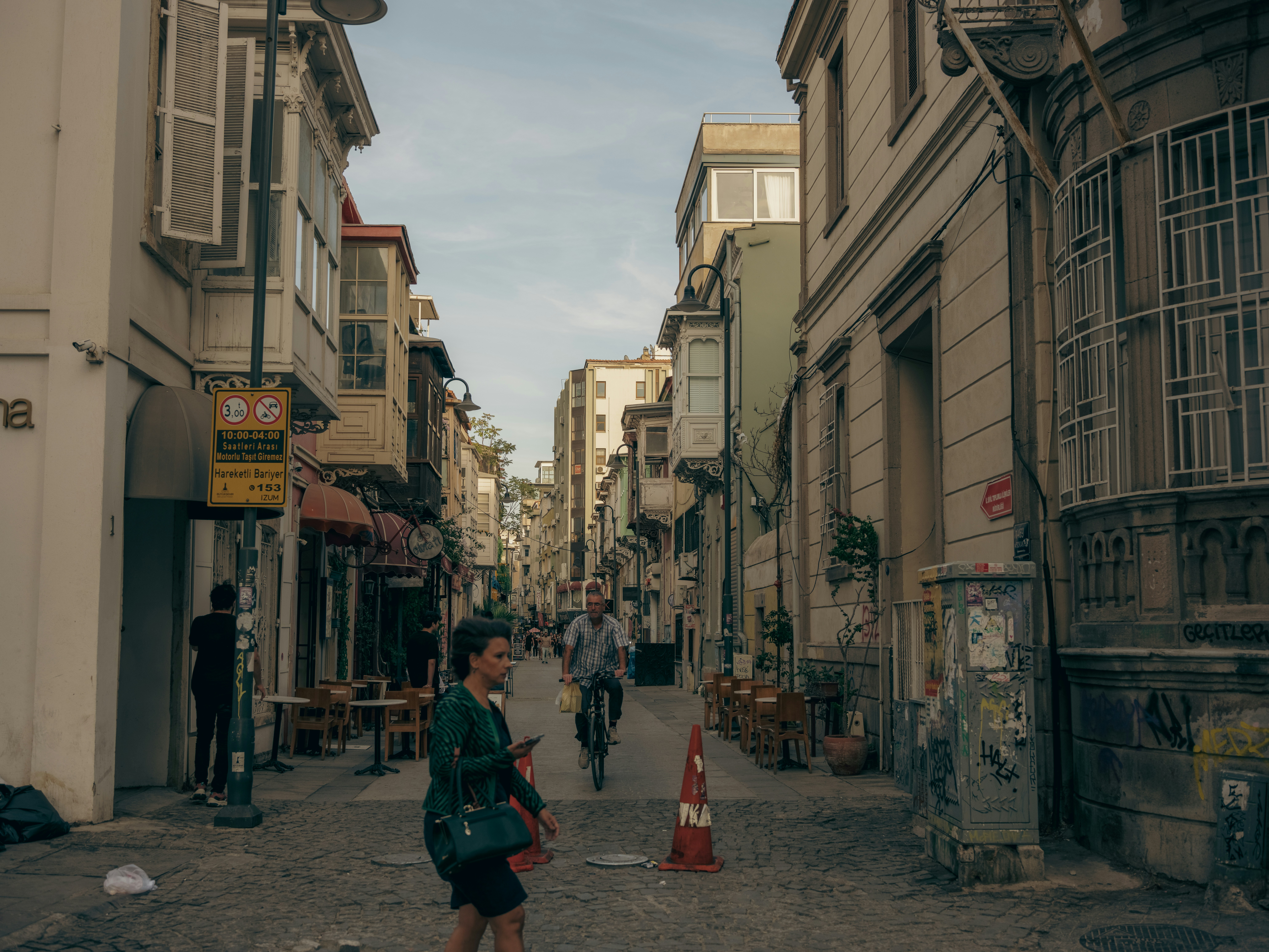 People walking down a narrow street with buildings
