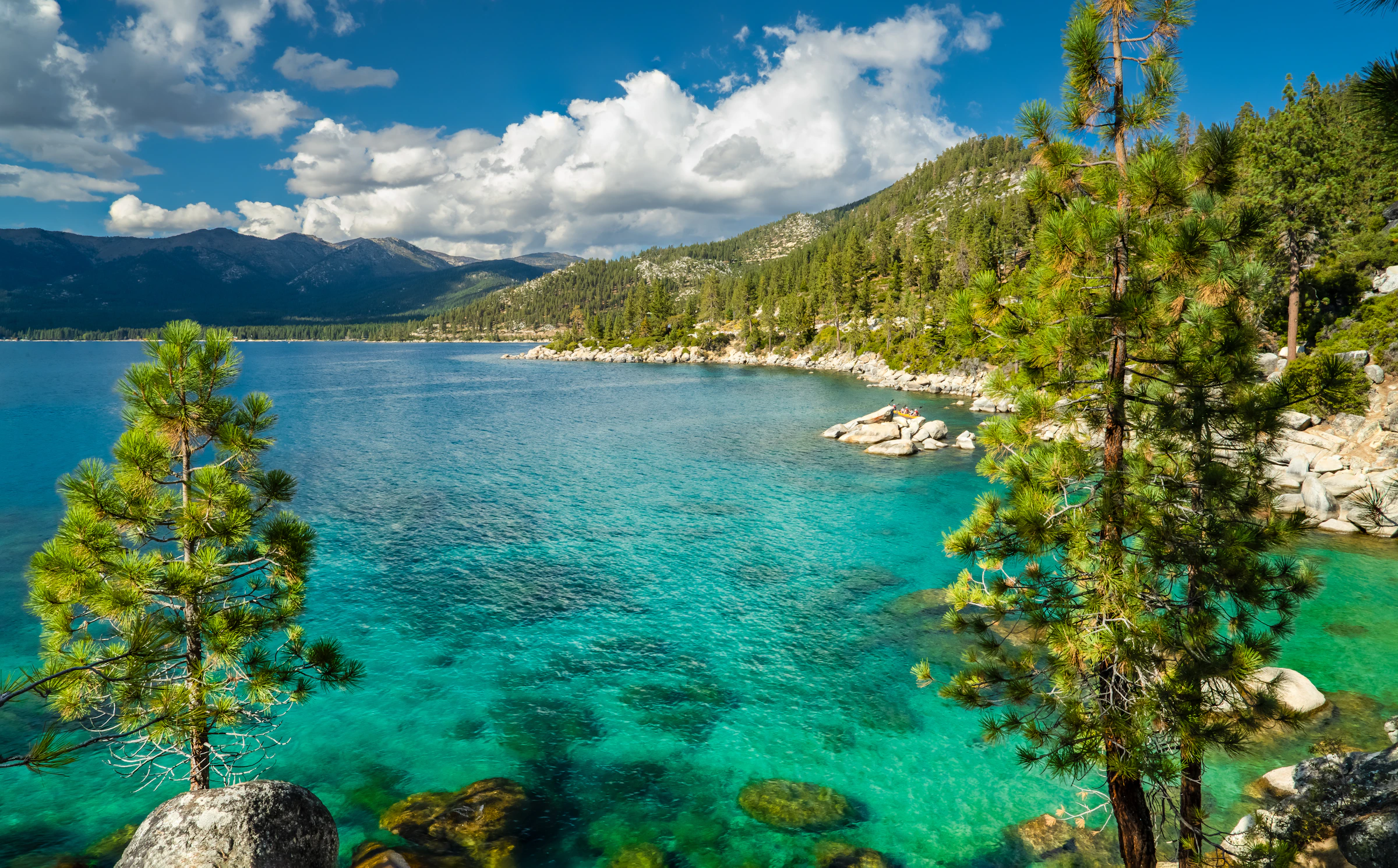Crystal-clear turquoise Lake Tahoe water, granite shoreline and Sierra mountains