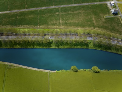 Aerial view of a river flowing through green fields.