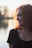 Young woman with curly red hair smiling outdoors