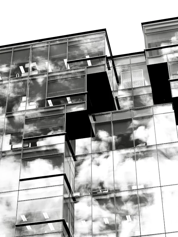 Glass building facade reflecting clouds