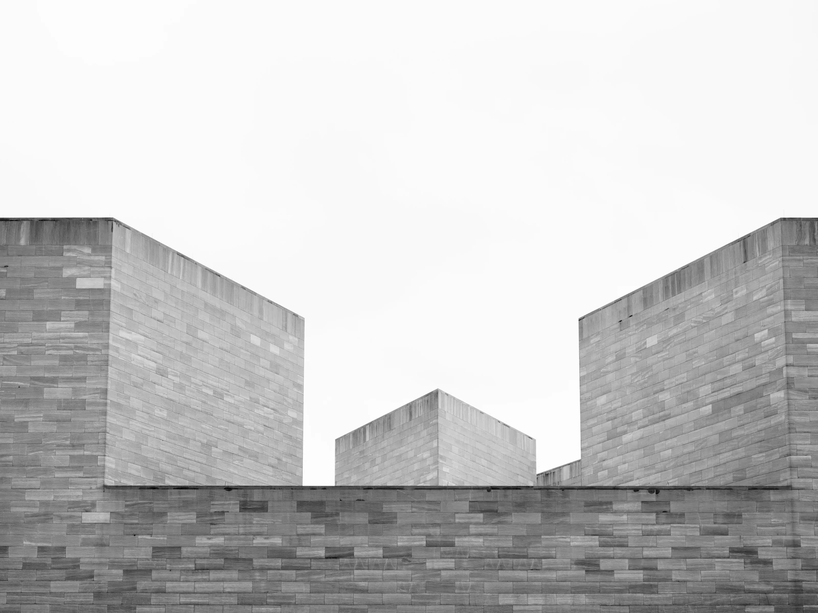 Volumes géométriques d’un bâtiment en pierre, photographiés en noir et blanc.