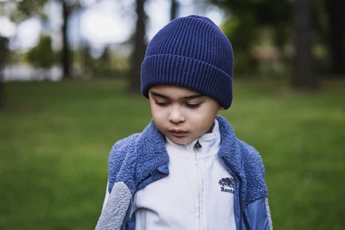 Boy in blue beanie and jacket outdoors