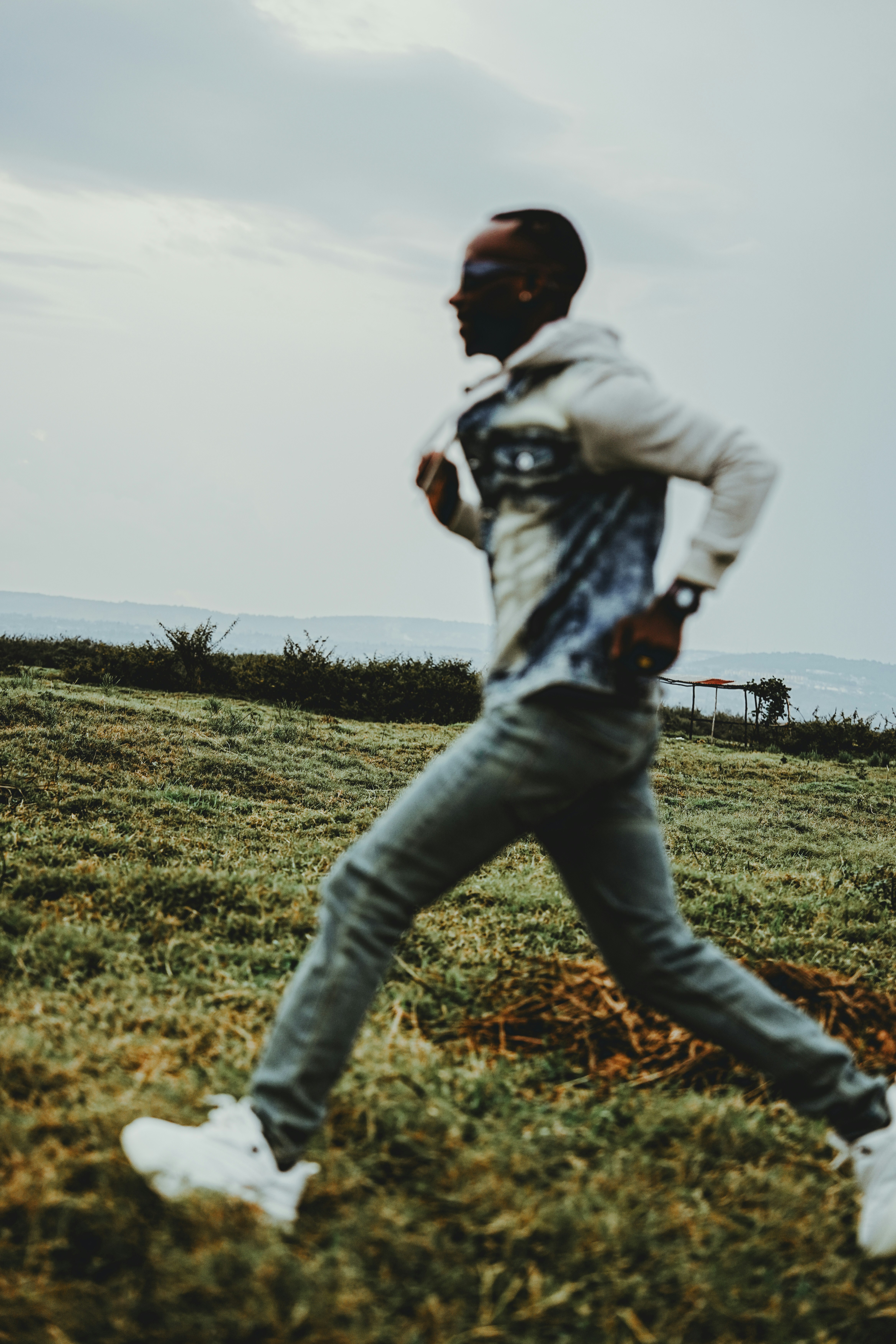 Mann läuft auf grasbewachsenem Hügel im Freien