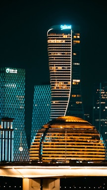 Modern illuminated skyscrapers at night in a city.