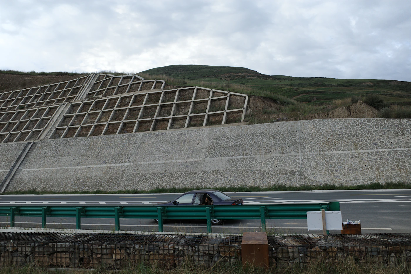 Engineered retaining wall along a graded roadway, the kind of project that typically requires a permit and stamped engineering review