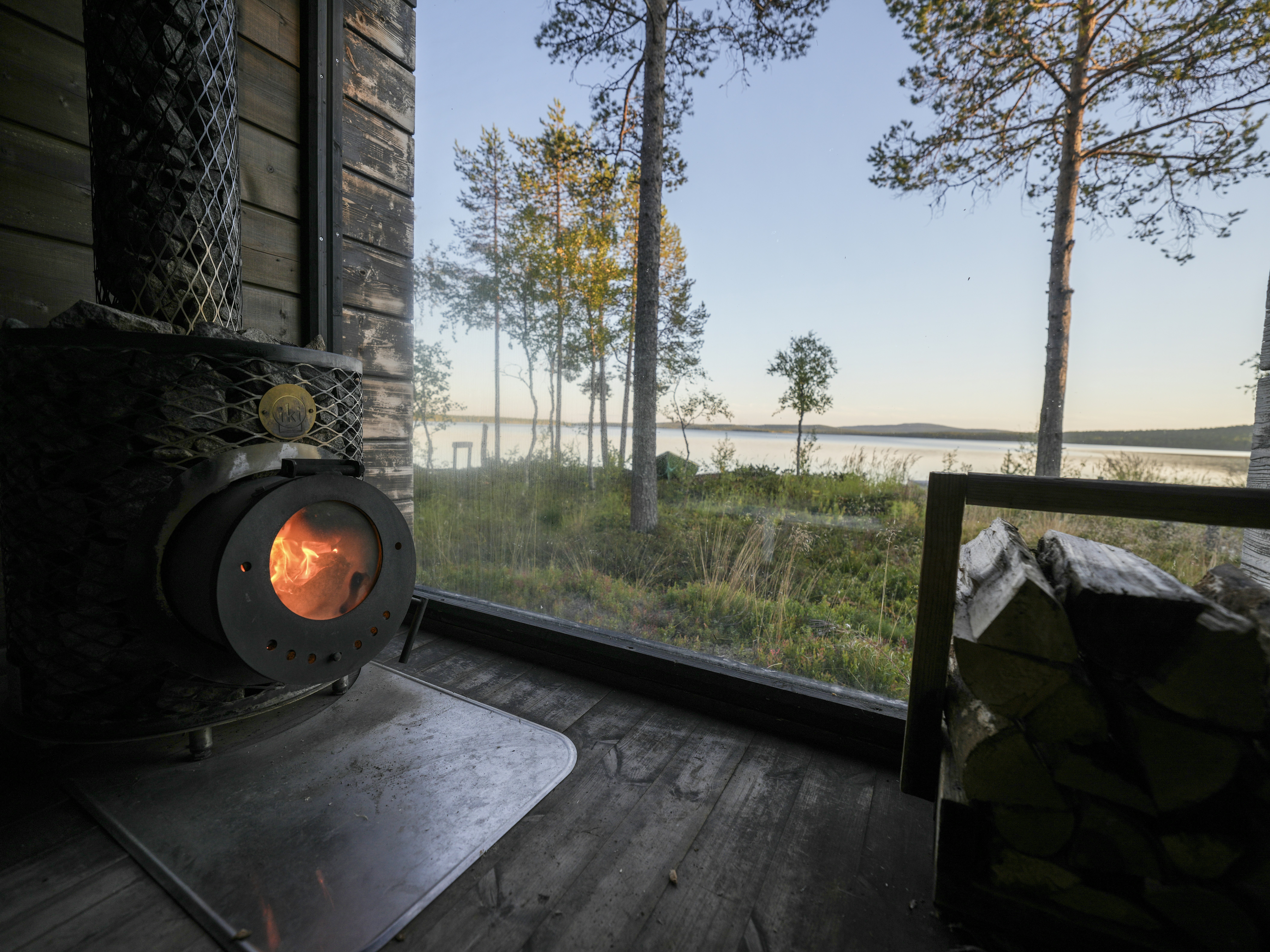 Cozy cabin with wood stove overlooking a serene lake.