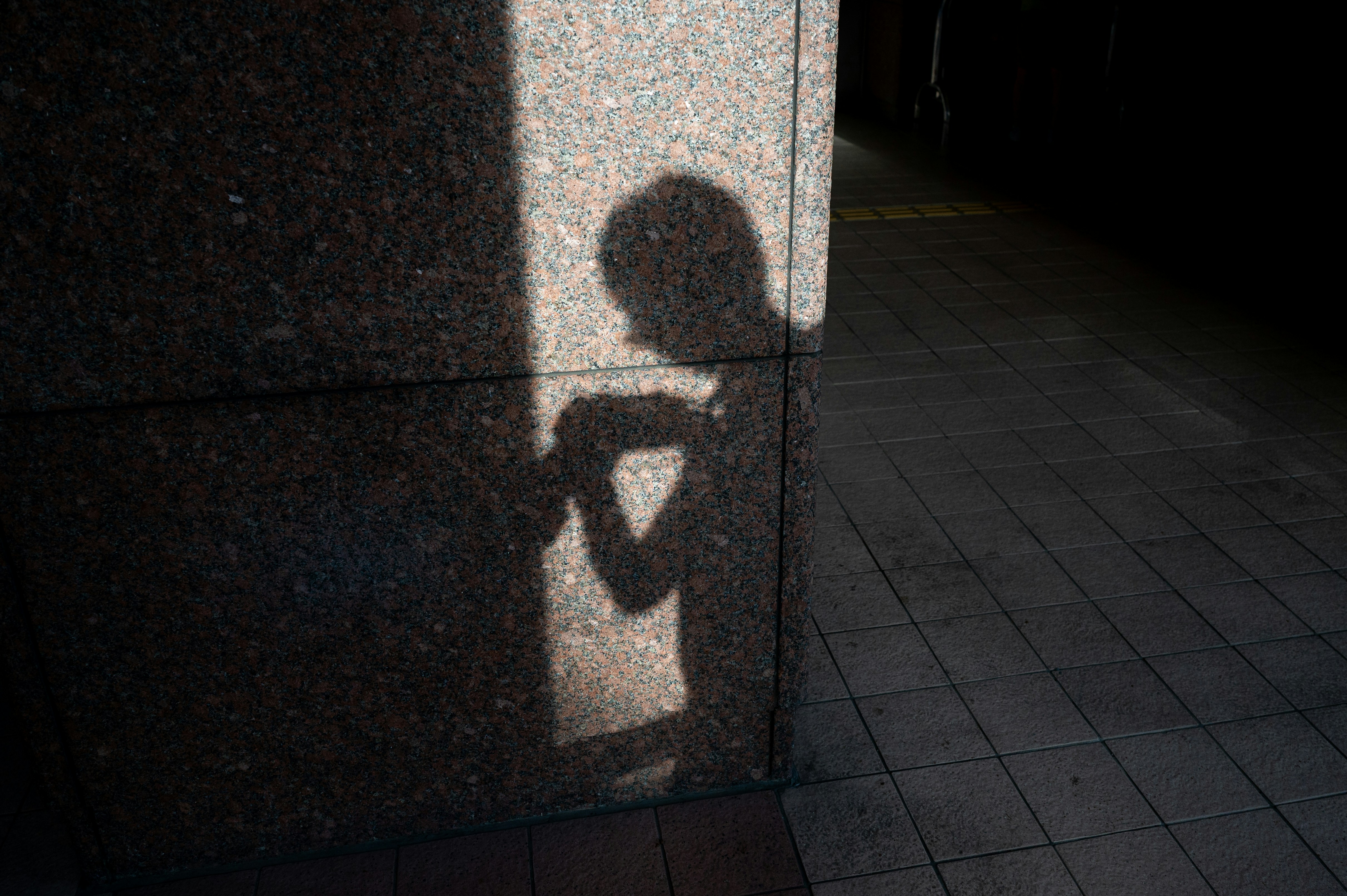 Shadow of a person on a textured wall