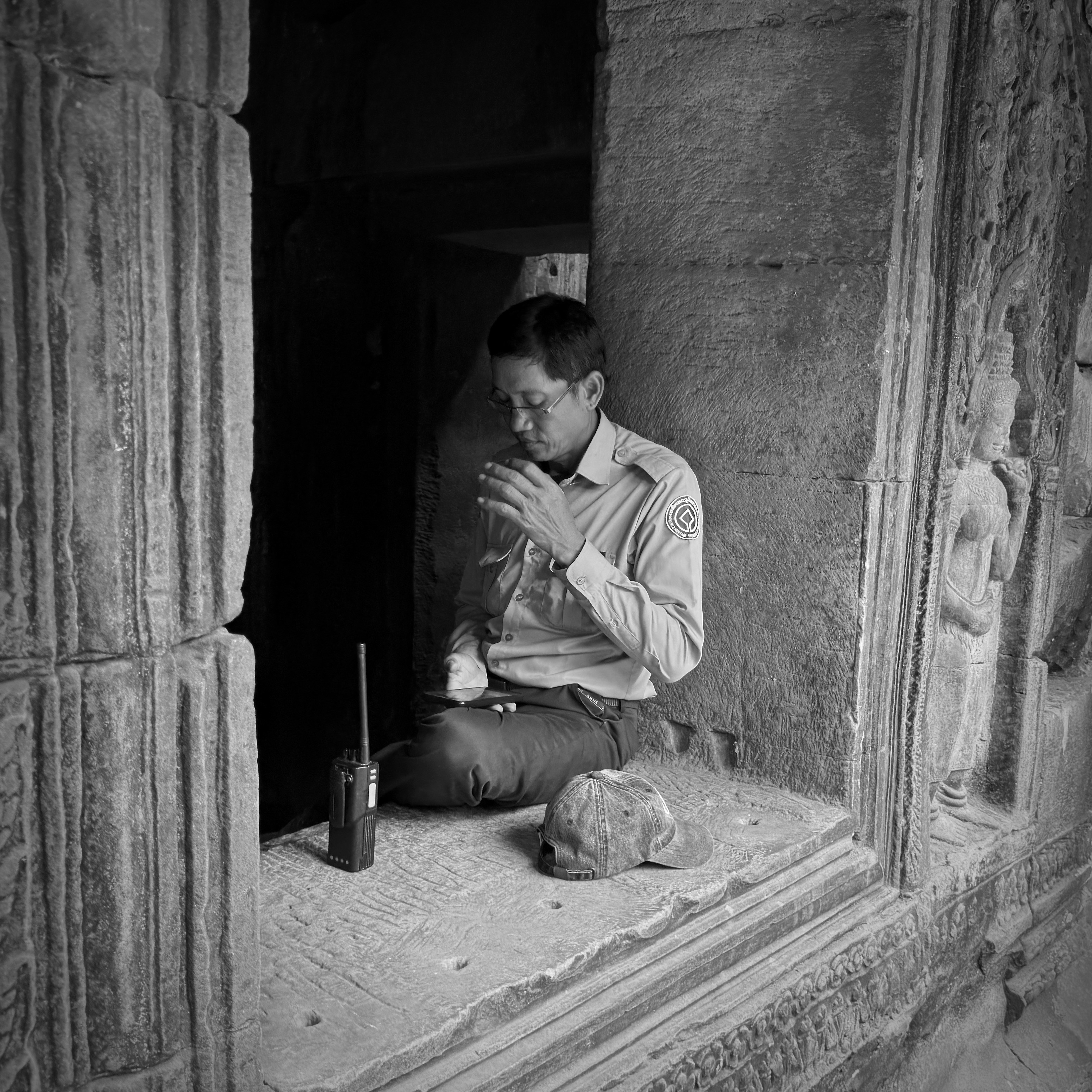 Man sitting in ancient stone doorway with radio.