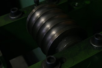 Close-up of a metal roller with grooves on a machine.