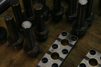 Metal parts and components arranged on a wooden surface.