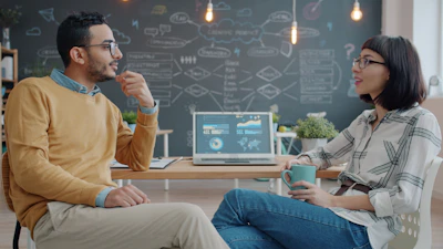 Two colleagues discussing ideas in a modern office.