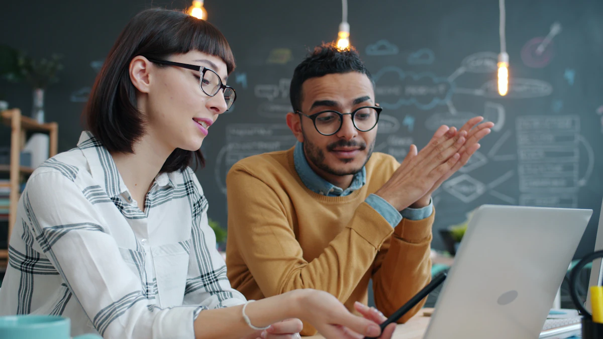 Two colleagues reviewing work together on a laptop