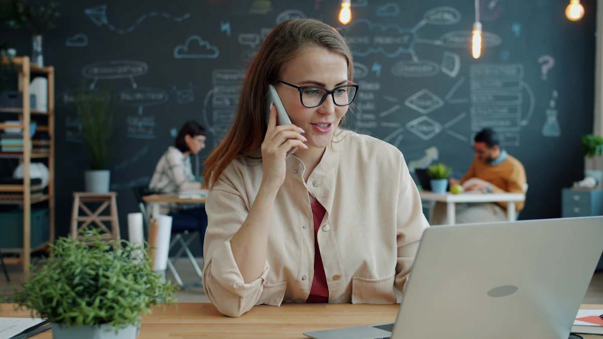 Woman on the phone at a desk with a laptop