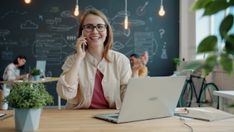 Smiling woman talking on phone in modern office.