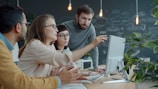Team collaborating around a computer in an office.