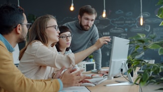 Team collaborating around a computer in an office.