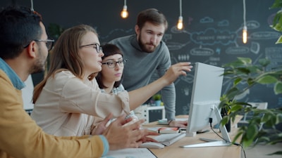 Team collaborating around a computer in an office.