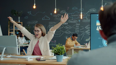 Woman celebrating success at her office desk