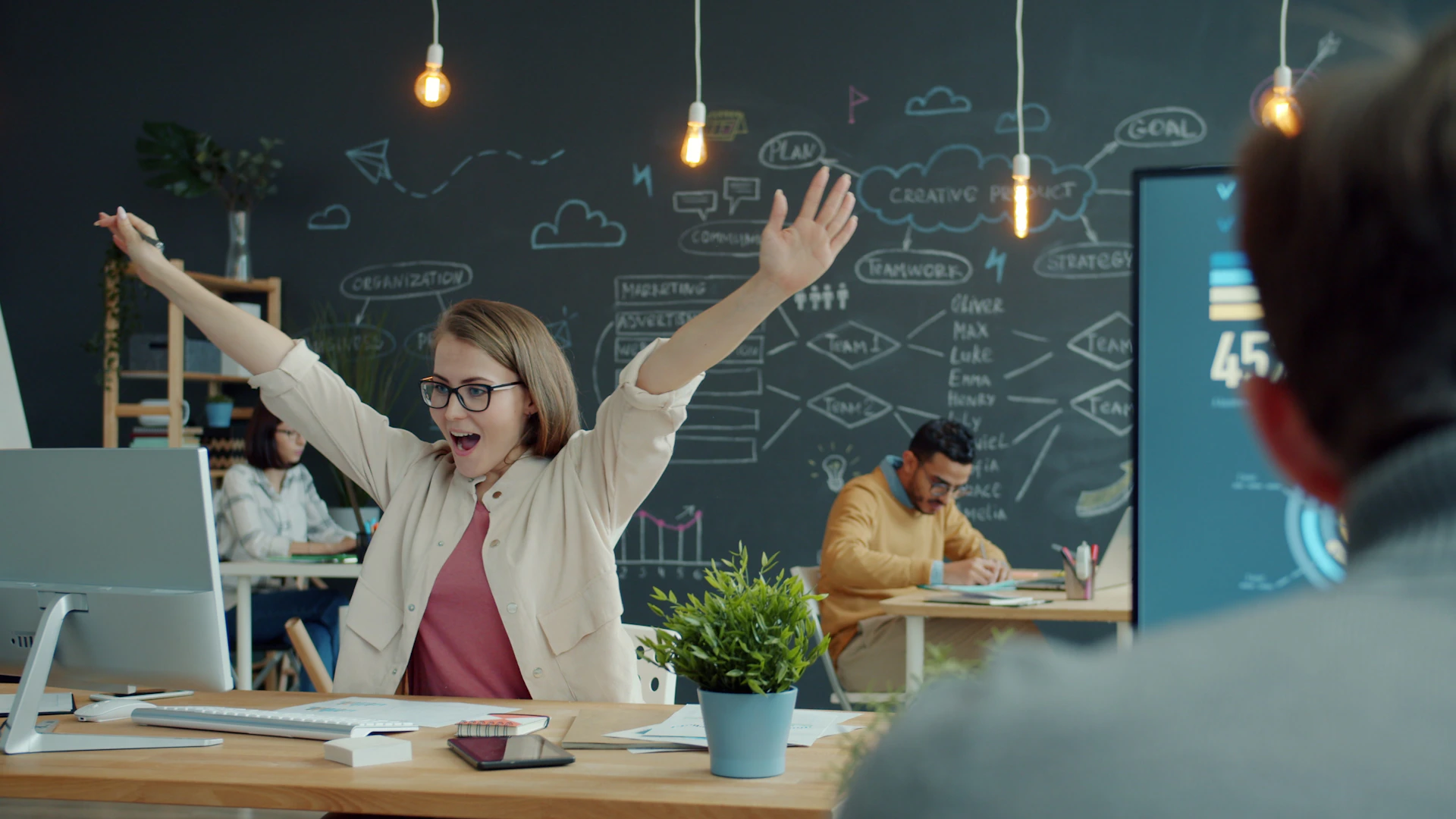 Woman celebrating success at her office desk.