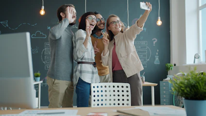 Four friends taking a selfie in the office.