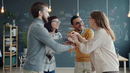 Diverse team celebrates success with a huddle.