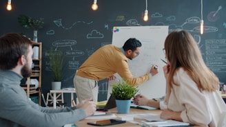 Man presenting ideas on whiteboard to colleagues