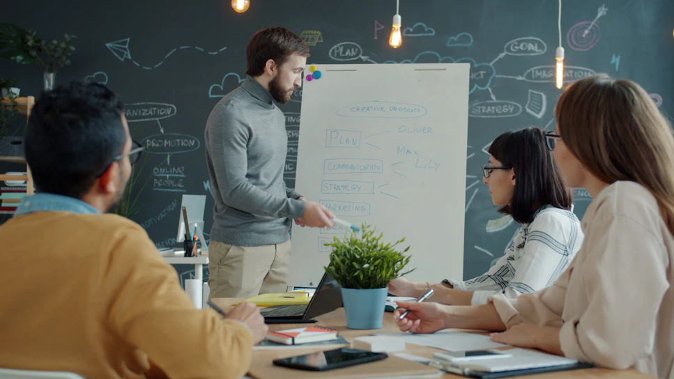 Team collaborating around a whiteboard in a modern office.