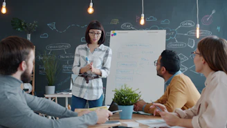 Woman presents to colleagues at a whiteboard meeting.