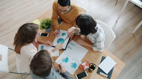 Team collaborating around a table with charts.